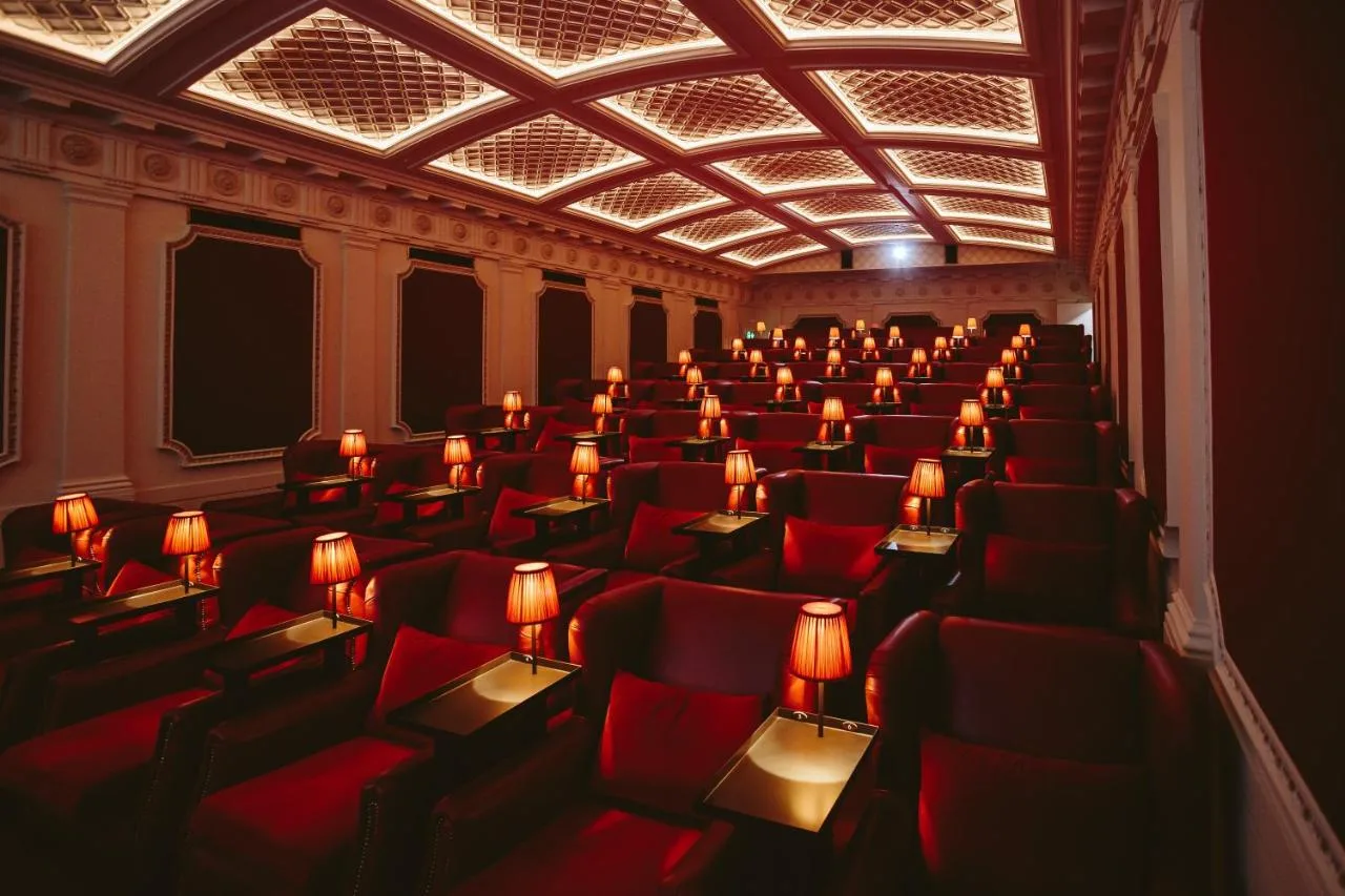 an empty cinema room with red chairs and lights at The Scotsman Hotel in Edinburgh